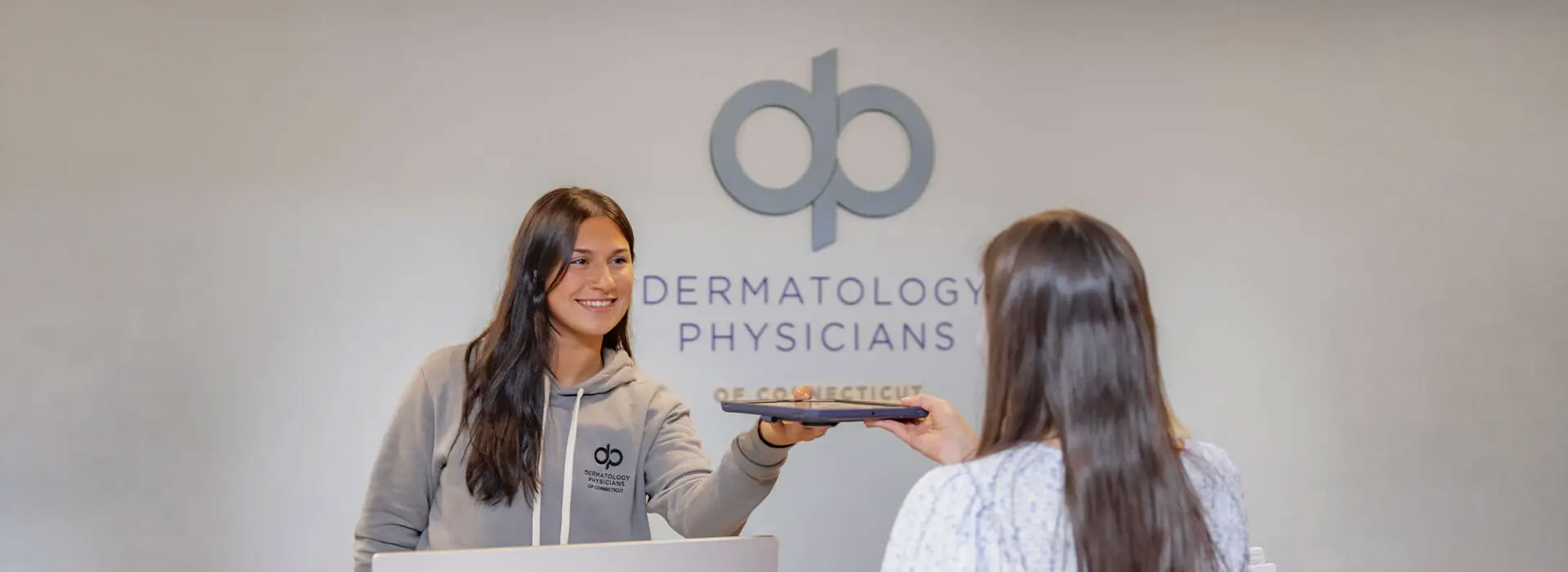 A patient checking in at the Dermatology Physicians of Connecticut Oxford office