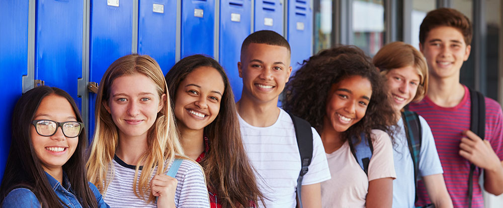 high school teens back to school standing in front of lockers